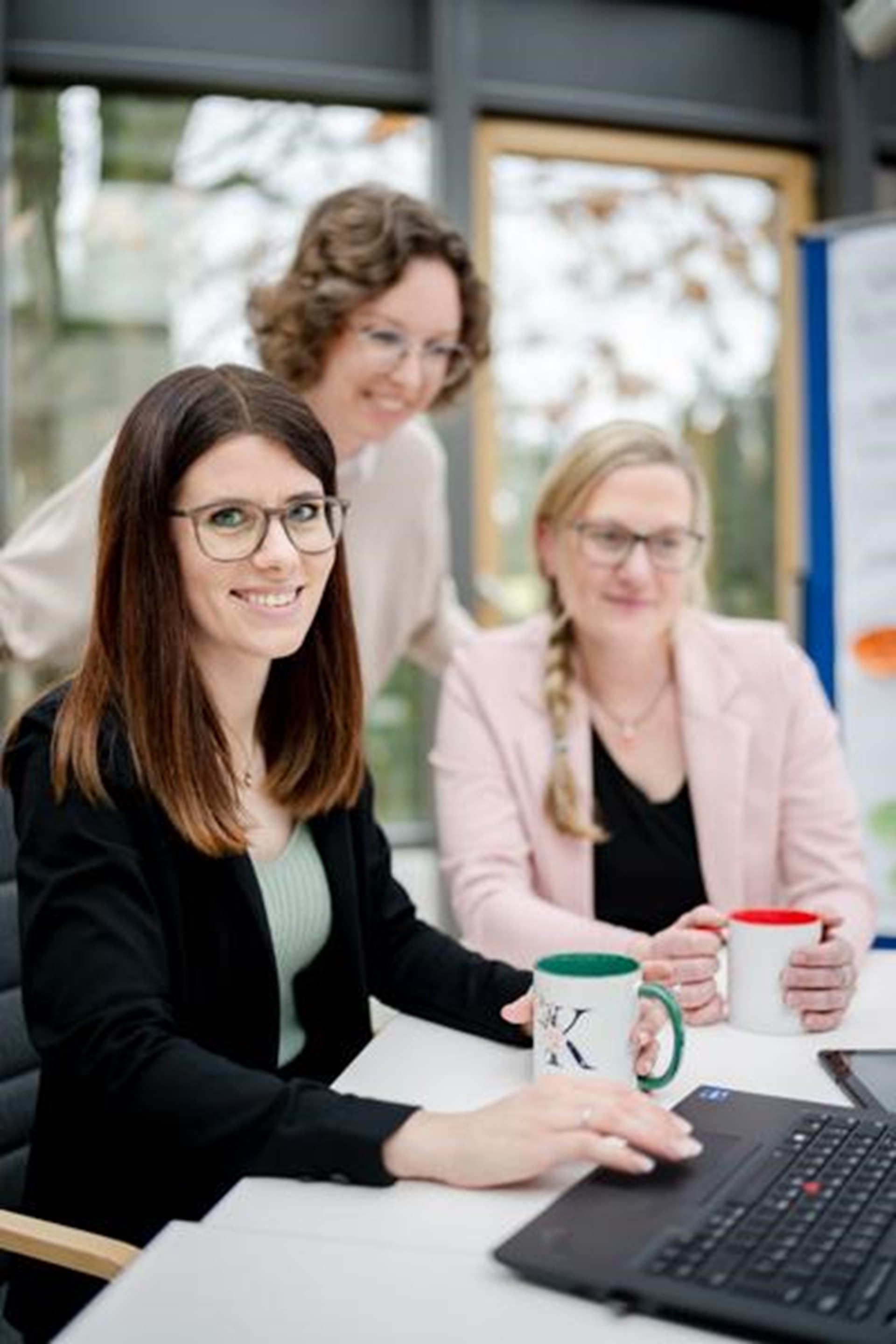 Drei Frauen schauen auf einen Laptop