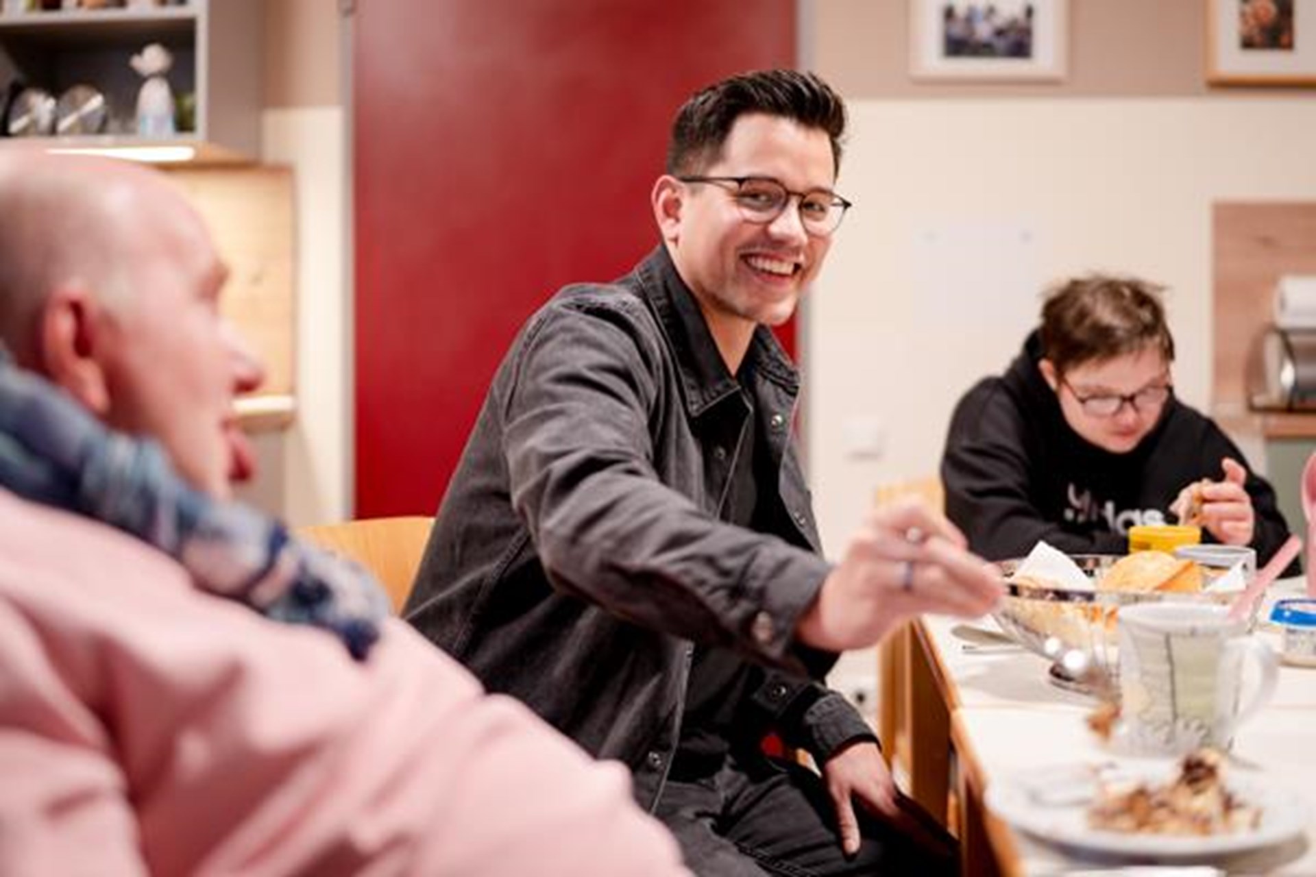 Drei Menschen sitzen am Tisch