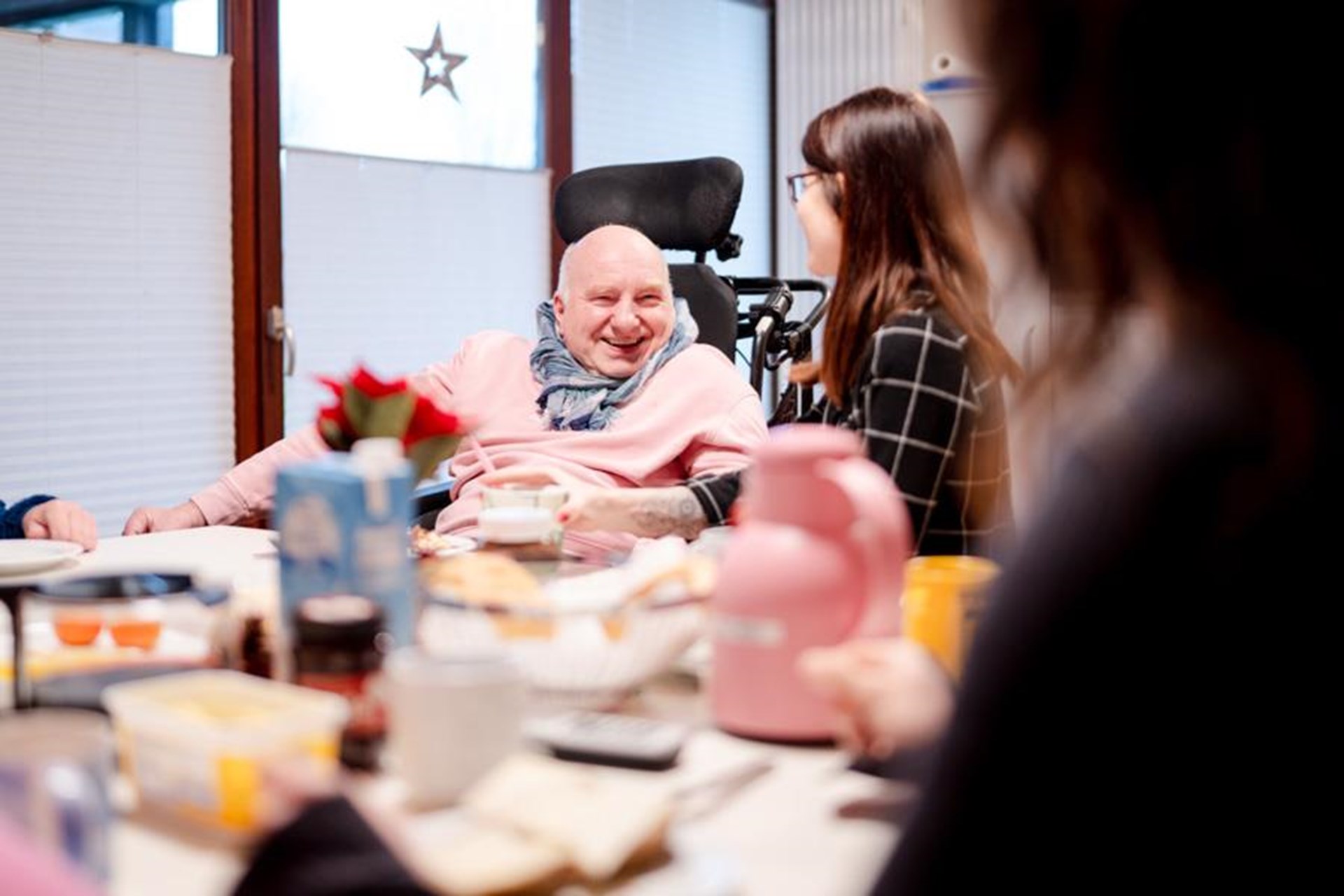 Ein Mann im Rollstuhl bekommt Essen von einer Frau angereicht