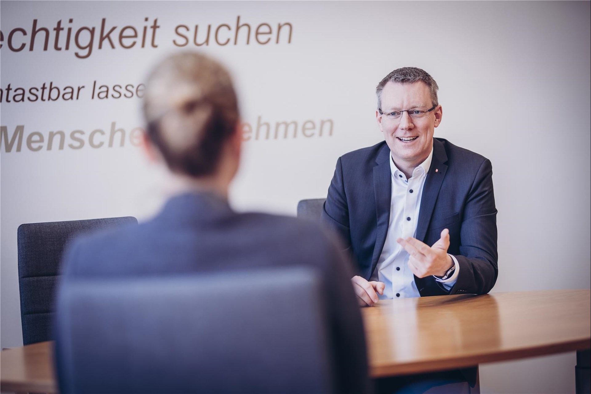 Mann sitzt am Tisch und spricht