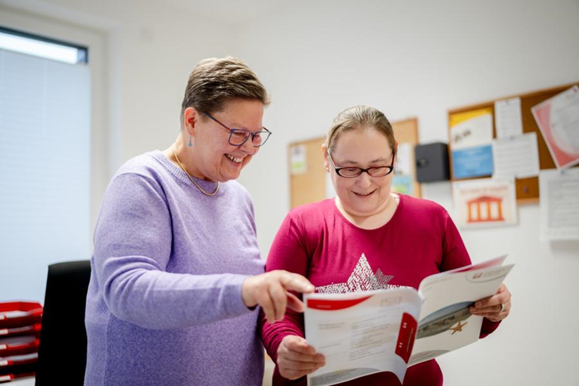 Zwei Frauen schauen gemeinsam in ein Magazin