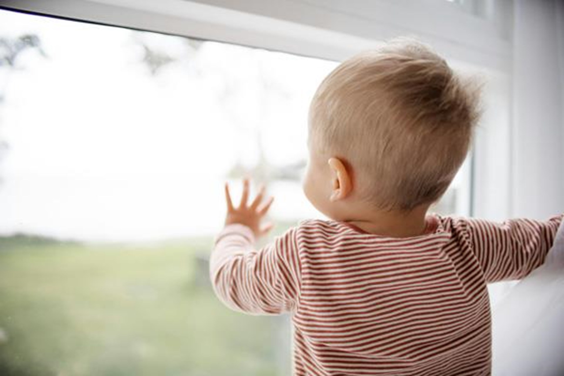 Kleinkind schaut aus dem Fenster