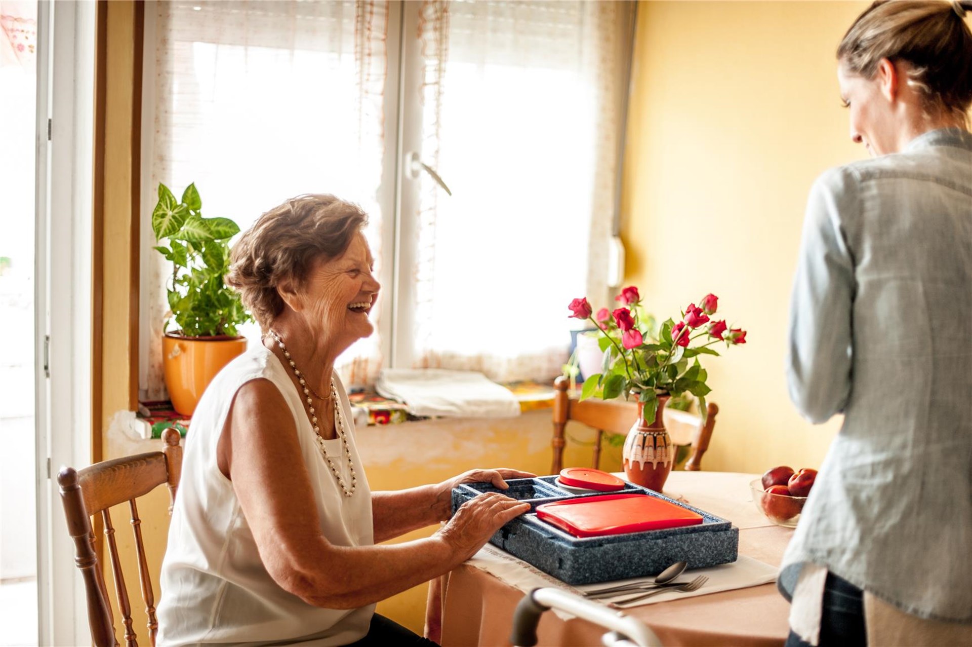 Seniorin hat eine Box mit Essen vor sich liegen